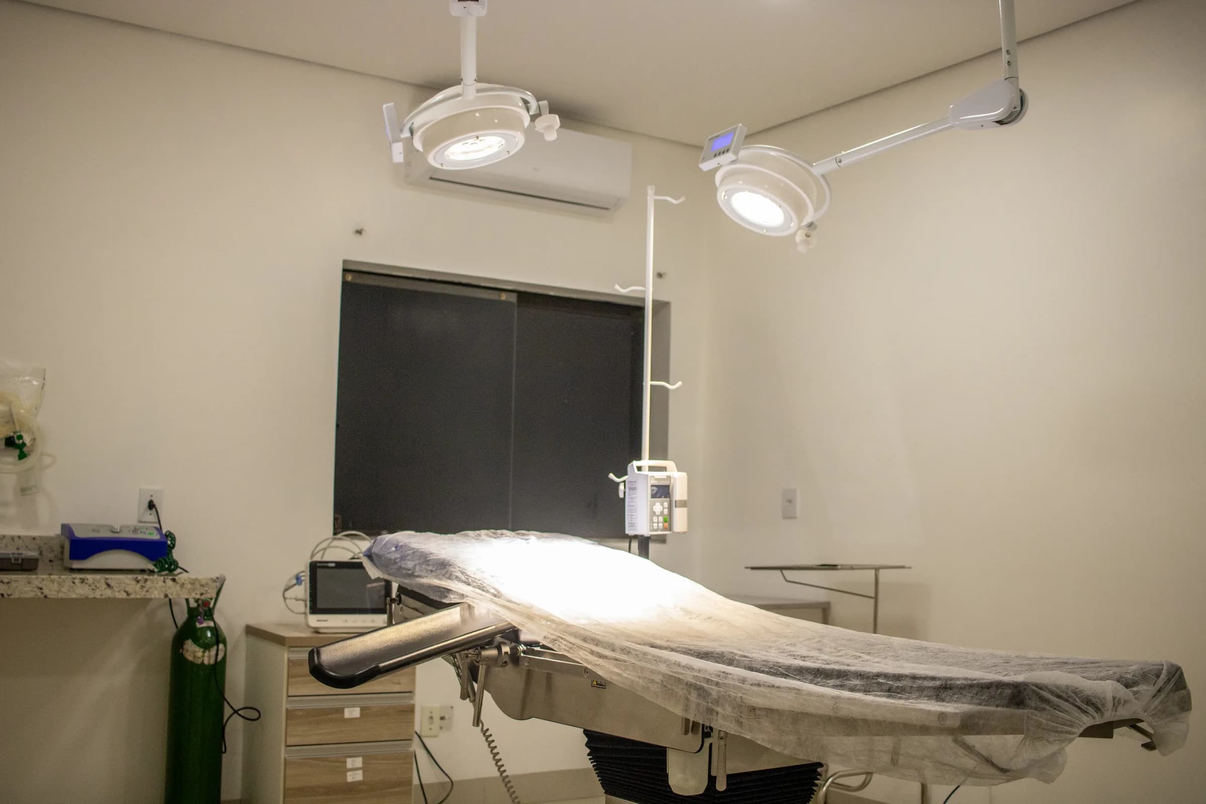 Sala de procedimentos com foco cirúrgico e equipamentos de imagem