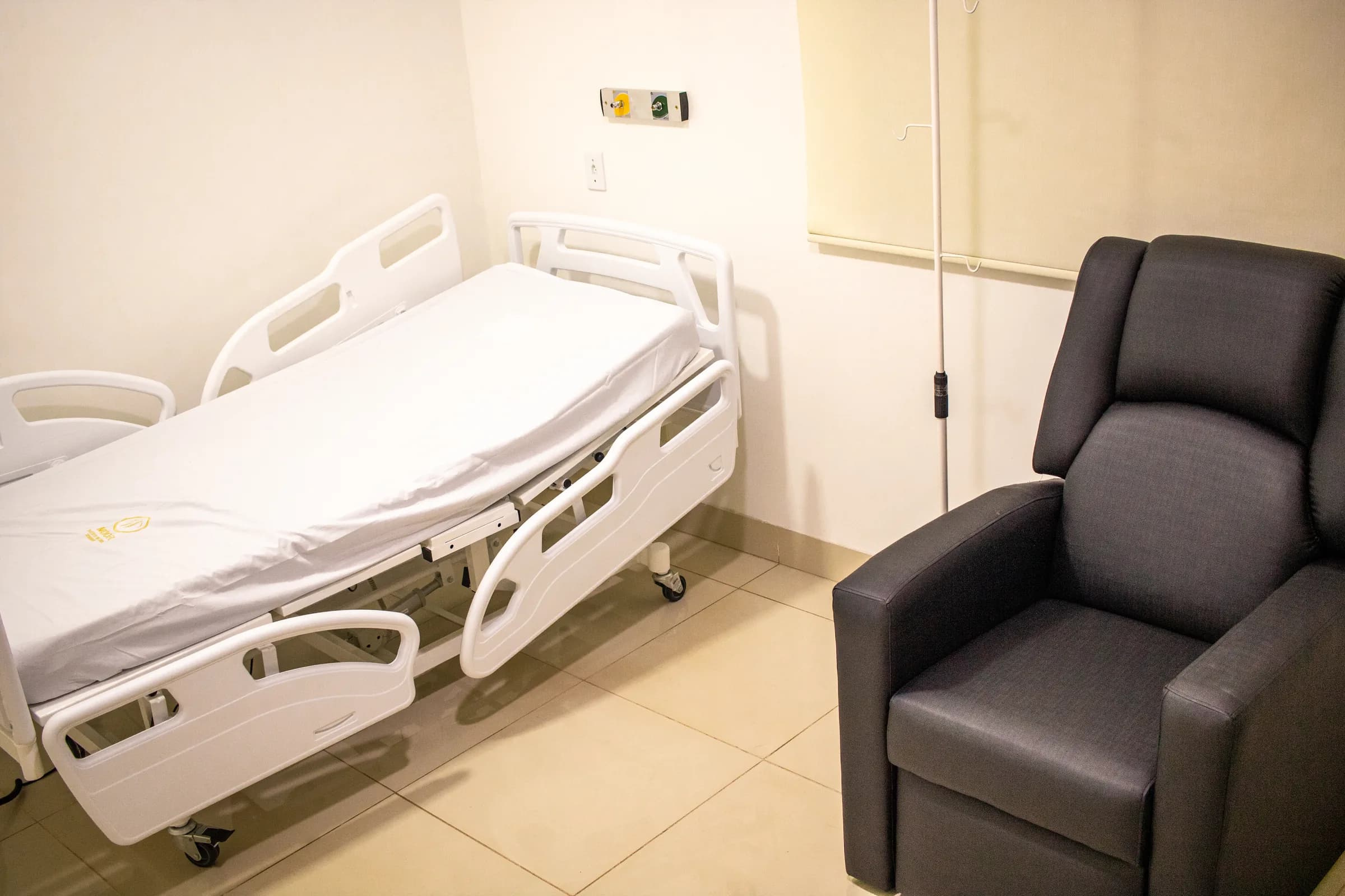 Sala de recuperação com leito e poltrona reclinável